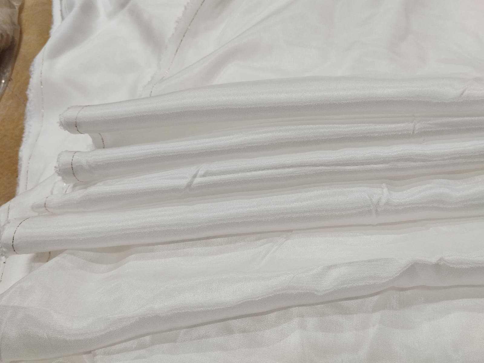 Soft white Audi fabric with a lightweight sheer texture and elegant shine ideal for dresses, sarees, dupattas, and designer garments.
