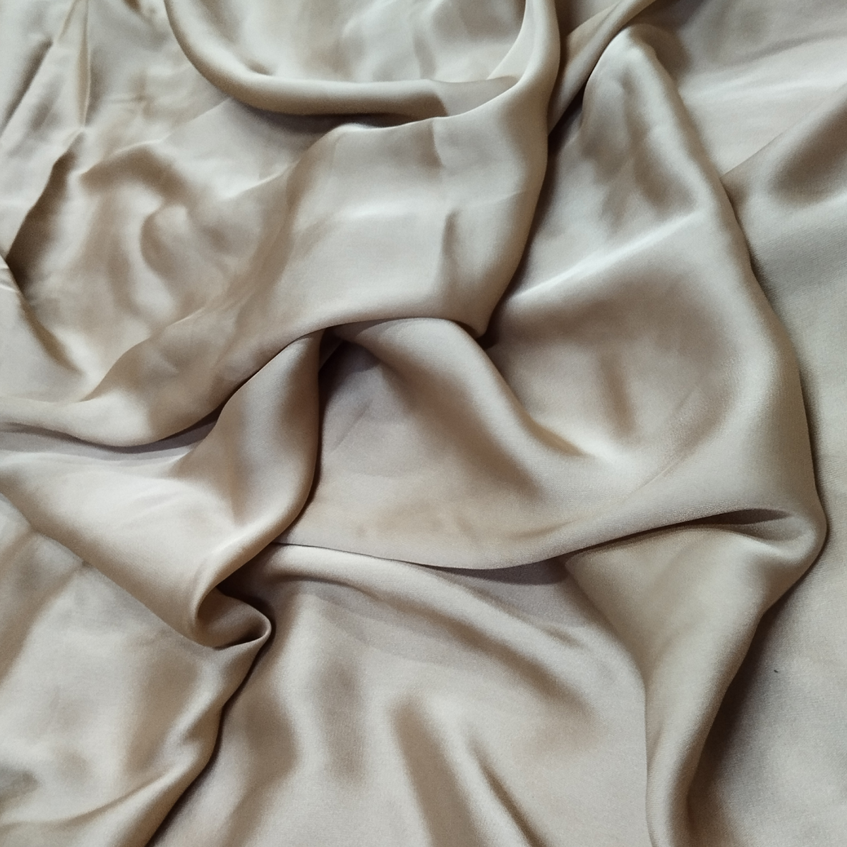Taupe beige satin fabric with a smooth silky texture and elegant flowing drape.