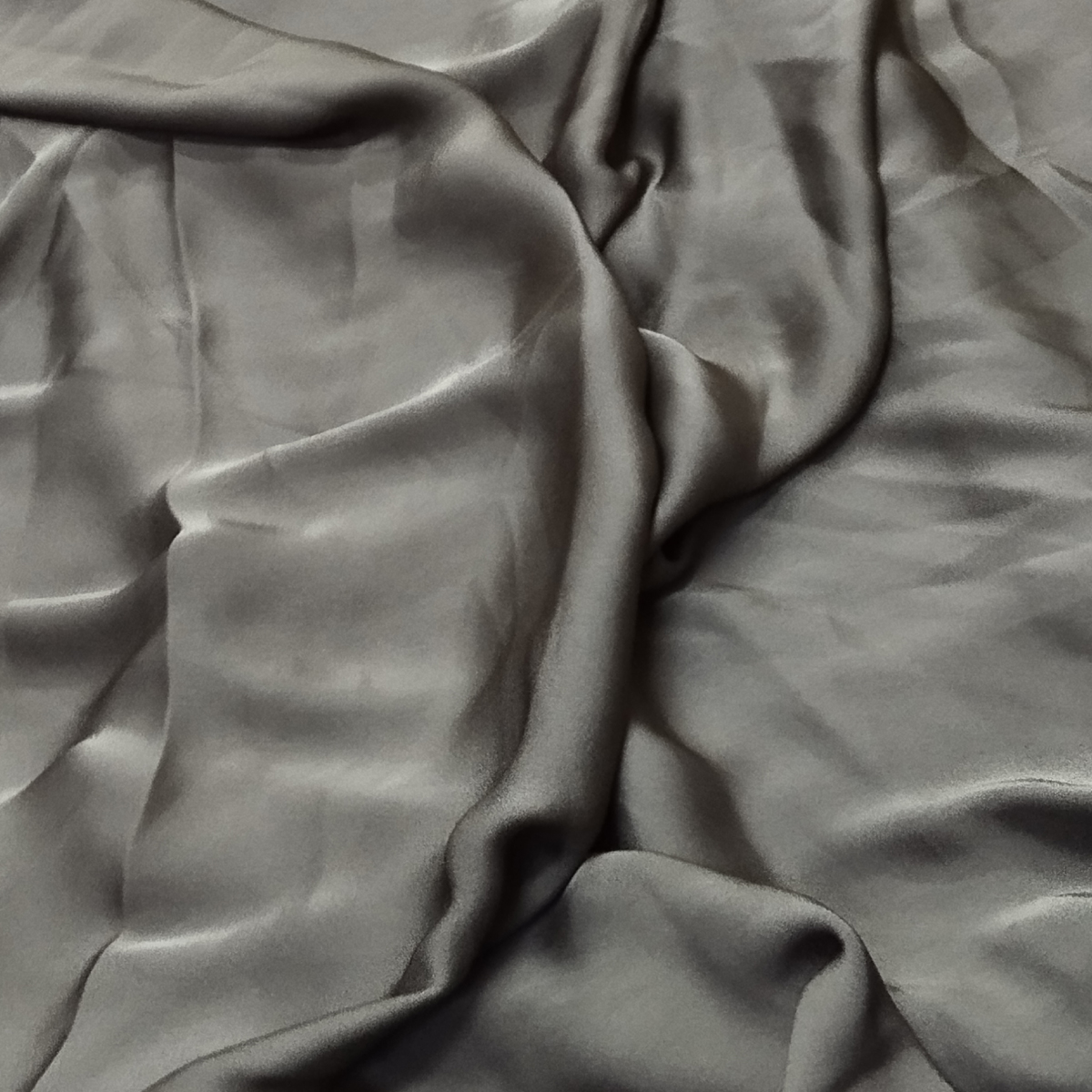 Charcoal grey satin fabric featuring a smooth silky texture, elegant sheen, and soft flowing drape