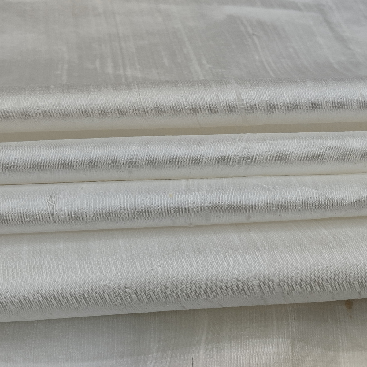 100 Heavy Silk fabric with smooth glossy texture and elegant swirl drape pattern.