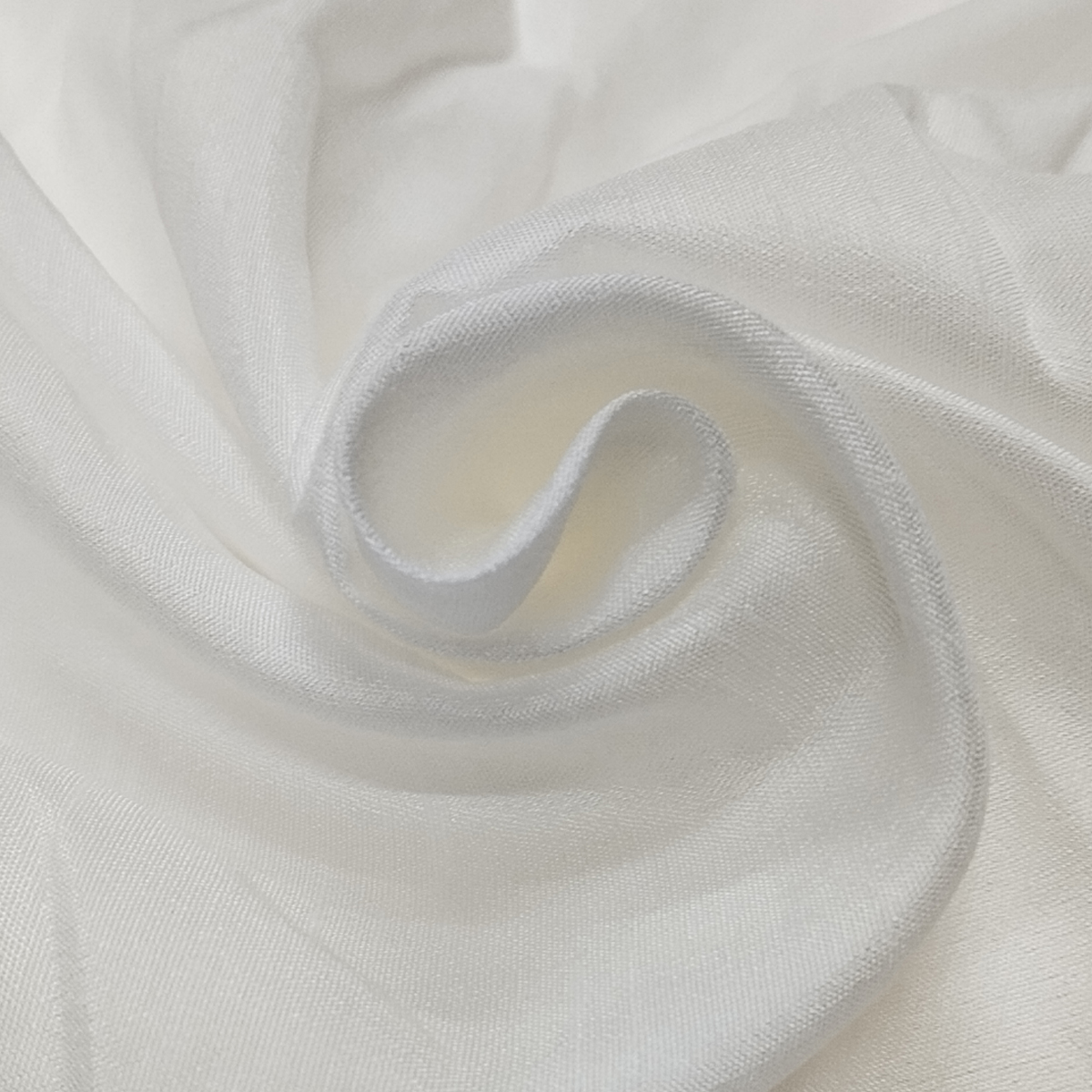 White Madras Silk fabric with soft sheen and elegant drape arranged in smooth folds.