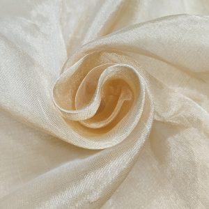 Soft pure tissue gold fabric with shiny texture and elegant drape arranged in swirl pattern.